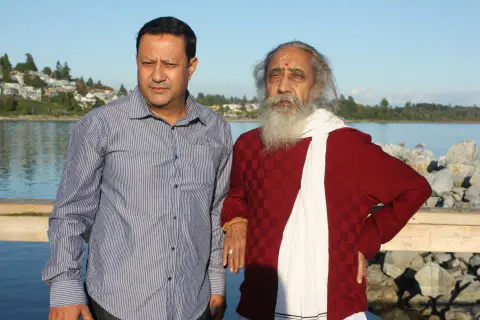 Nepali Baba standing with a companion beside the waterfront in Canada