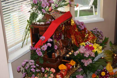 A decorated shrine with flowers, fruit and ceremonial objects