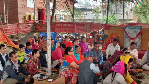 A large group of devotees seated together during a ceremony