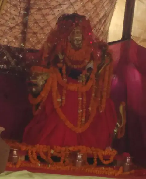 A decorated image of the goddess surrounded by offerings