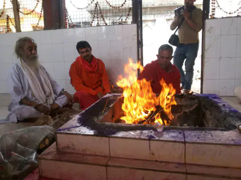 Nepali Baba and priests seated beside a sacred fire