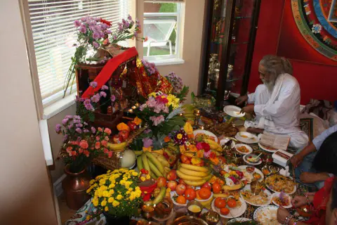 A flower-covered shrine surrounded by fruit and offerings