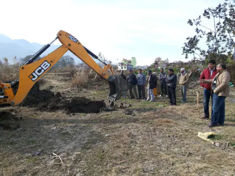 An excavator beginning preparation work at the temple site